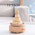 A three-tiered wooden rotating music wedding rocking horse with pink beads and a beige bear table decoration