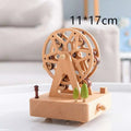A light wood-colored wooden rotating music ferris wheel toy with green tree figurines as a wedding rocking horse table decoration