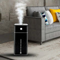 Black rectangular purifier humidifier with silver accent strip and teal control panel emitting mist from the top
