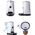 White and black pet automatic feeder with camera, food tray, water bottle, internal hopper, and battery power supply