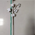 White artificial cotton stem with fluffy bolls and brown stems displayed with a green measuring tape showing length