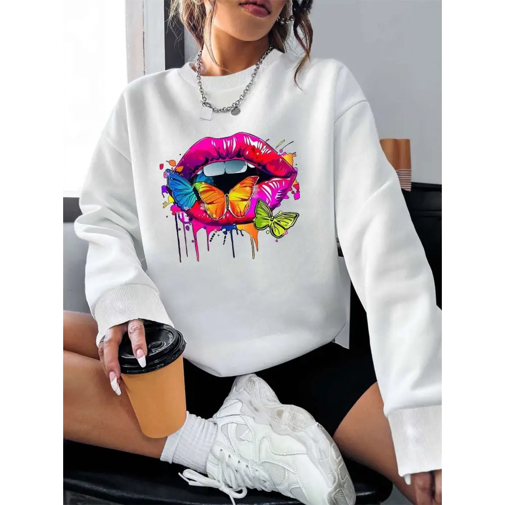 White crew neck sweatshirt featuring a vibrant butterfly lips graphic with colorful butterflies and paint drips