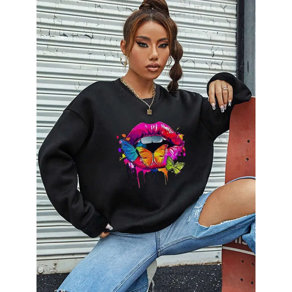 Black oversized crew neck sweatshirt featuring a vibrant white butterfly lips graphic with colorful butterflies and dripping paint effects