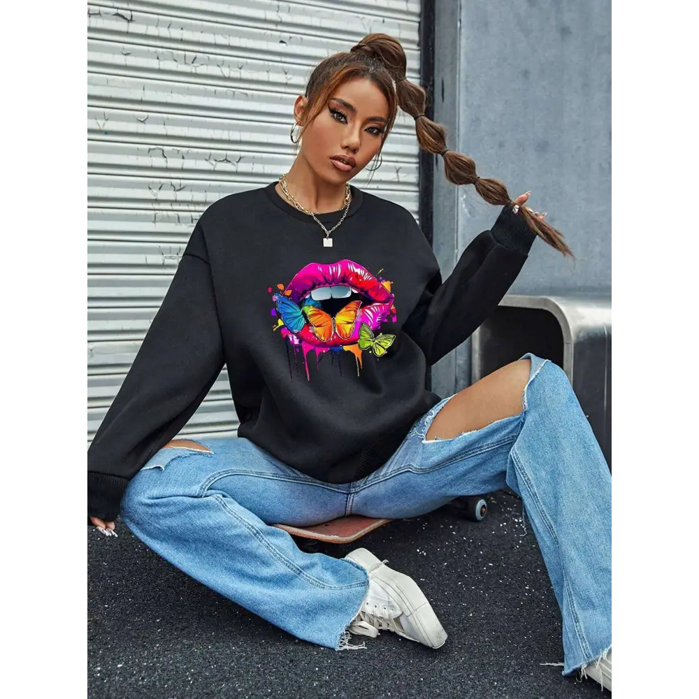 Black oversized crew neck sweatshirt featuring a vibrant white butterfly lips graphic with dripping paint design