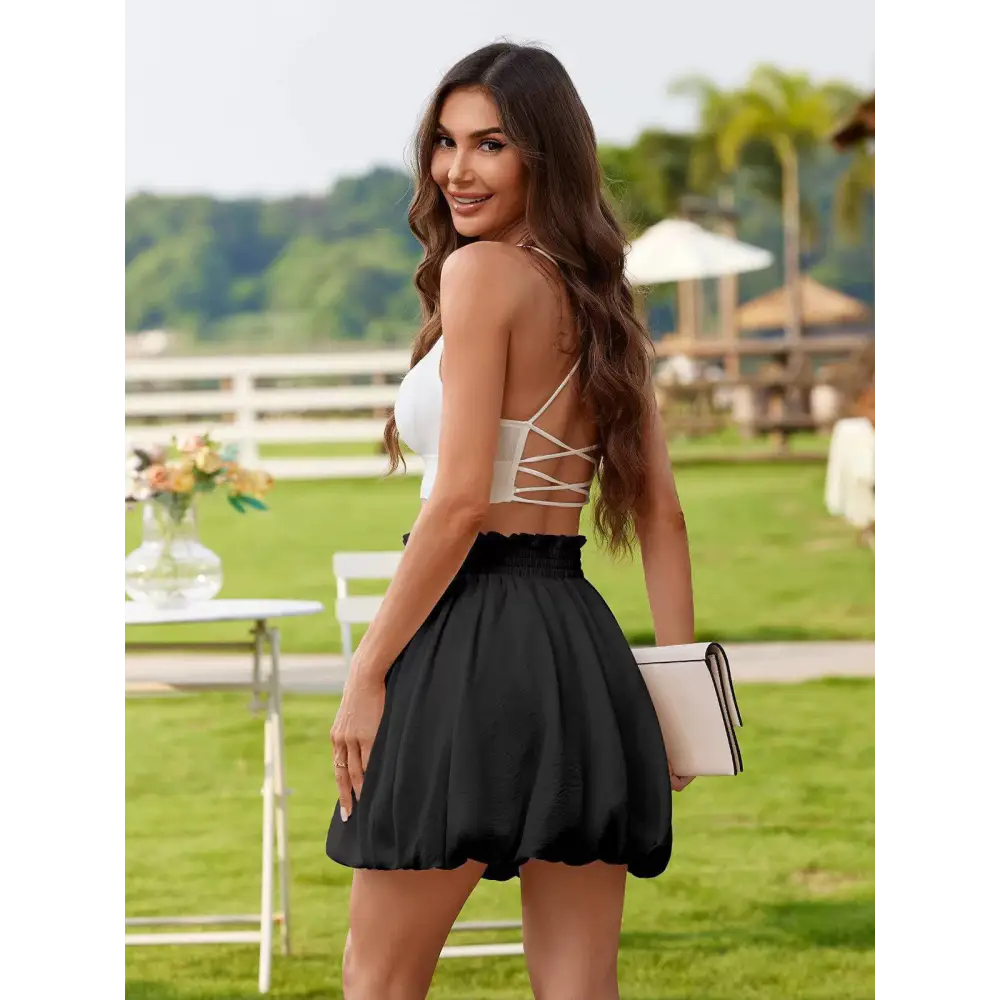 Black satin ruffled mini skirt with elastic waistband and flared hem in a graceful casual style