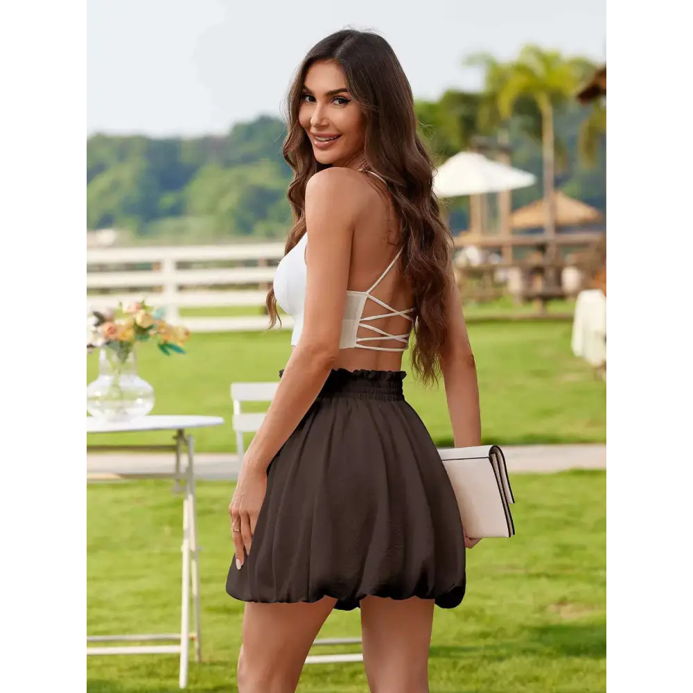 White casual graceful ruffled mini skirt with elastic waistband paired with white clutch with black trim