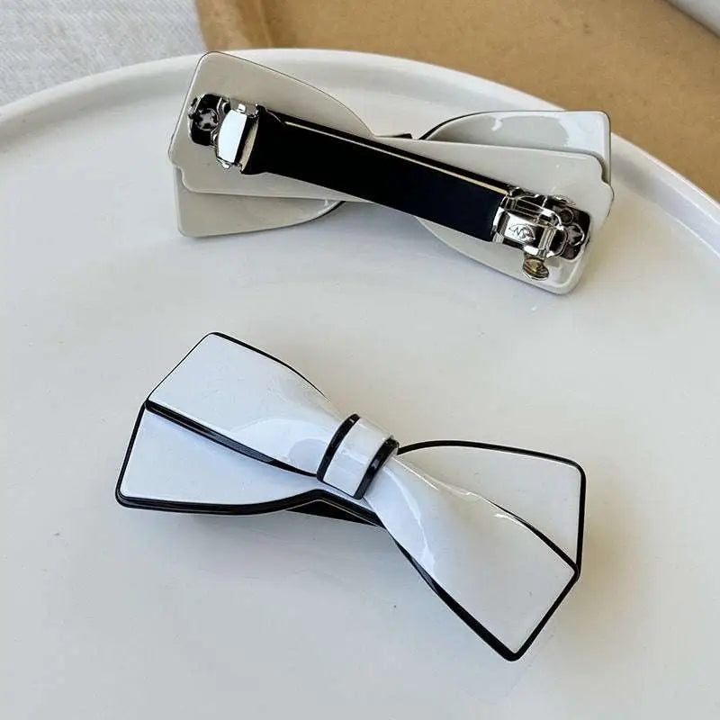 White ceramic camellia bow spring clip hairpin with black trim and silver clasp for female hair styling