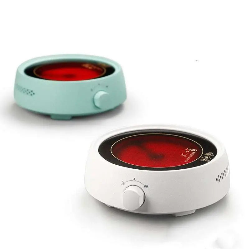 White ceramic electric earthenware oven with glowing red heating plate and black control dial for efficient cooking