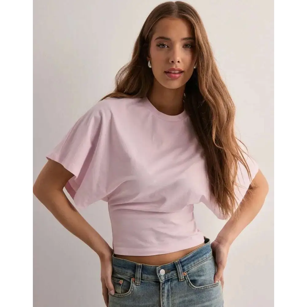 A soft pink white cotton ins fashion round neck cropped top with relaxed fit and short sleeves for summer wear