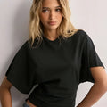 Black oversized short-sleeved top with relaxed fit and subtle ruching featuring a round neck cropped style