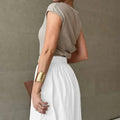 Beige ribbed knit sleeveless top with draped back paired with white cotton linen slimming large hem midi skirt