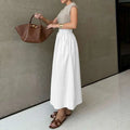 A brown leather tote bag with gold-tone hardware paired with a white cotton linen slimming large hem midi skirt