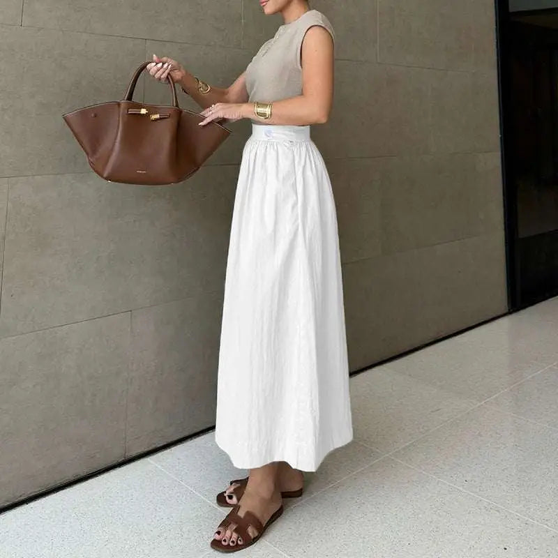 A brown leather tote bag with gold-tone hardware paired with a white cotton linen slimming large hem midi skirt