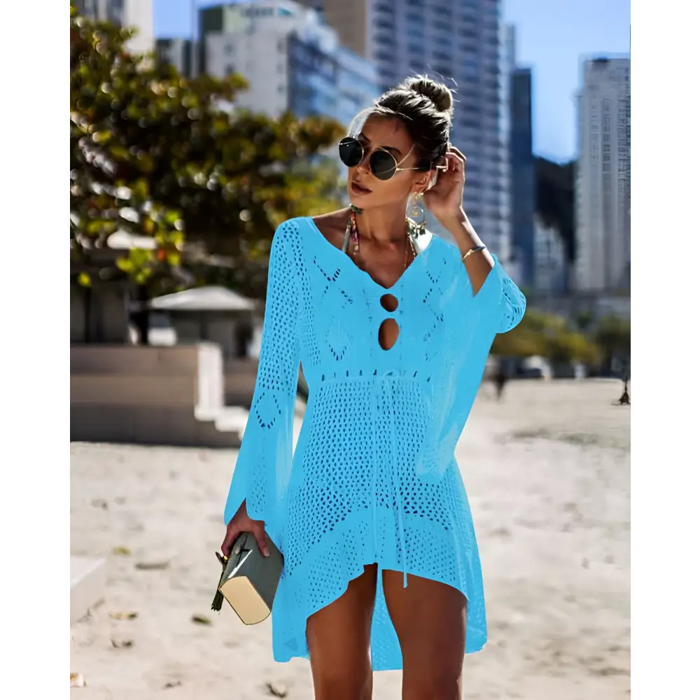 A vibrant turquoise long-sleeved crochet women swimsuit cover-up dress with v-neck and asymmetrical hemline