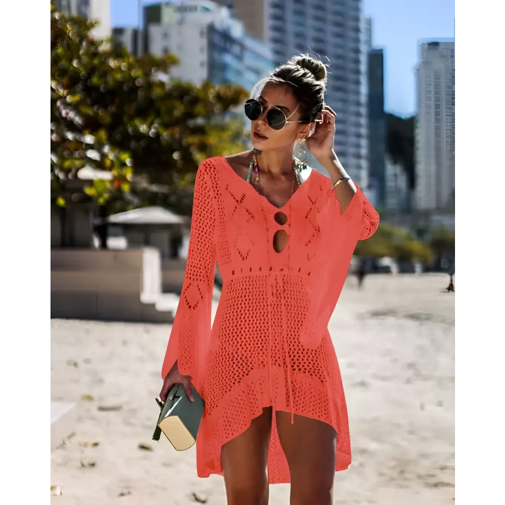 A vibrant coral long-sleeved crochet women swimsuit cover-up dress with v-neck and eyelet pattern for beachwear