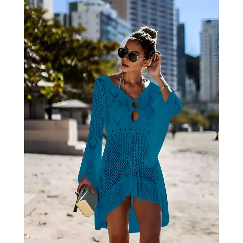 A vibrant turquoise long-sleeved crochet women swimsuit cover-up dress with v-neck and decorative cutouts
