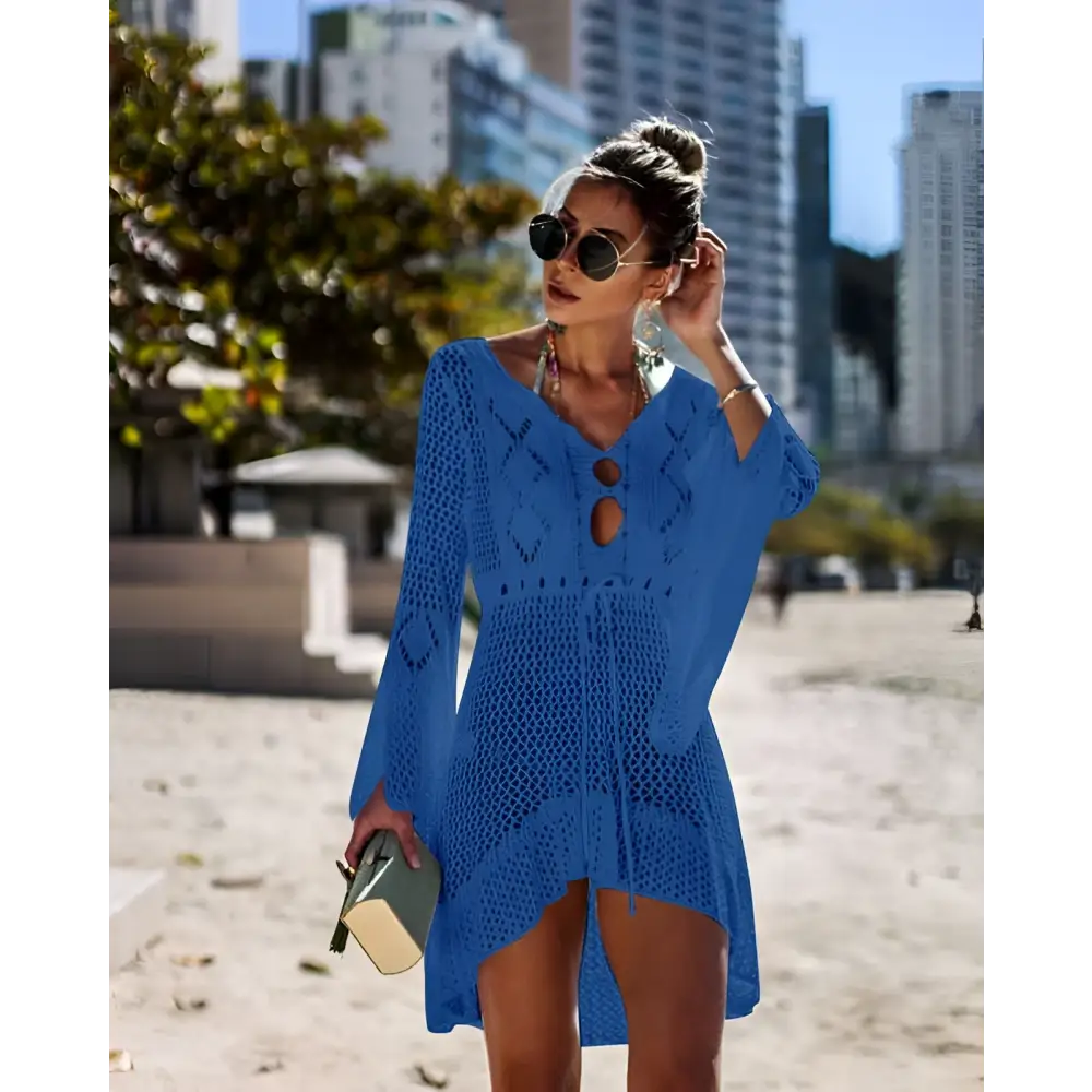 A vibrant blue long-sleeved crochet women swimsuit cover-up dress with v-neck and decorative cut-out details
