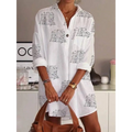 White slim shirt dress featuring black cursive letter printed design on cotton fabric with rolled-up sleeves