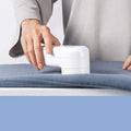 White electric lint and bulb remover with sleek compact design for easy use on luxury women’s fashion fabrics