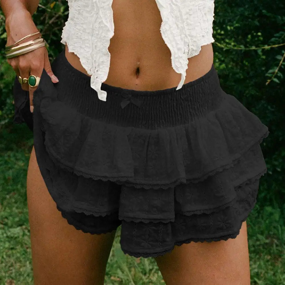 Black ruffled shorts with smocked waistband and lace trim complementing the white eyelet lace bow decorative bud skirt