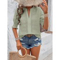 Light green short-sleeved blouse with delicate white eyelet embroidery and v-neckline featuring puff sleeve design