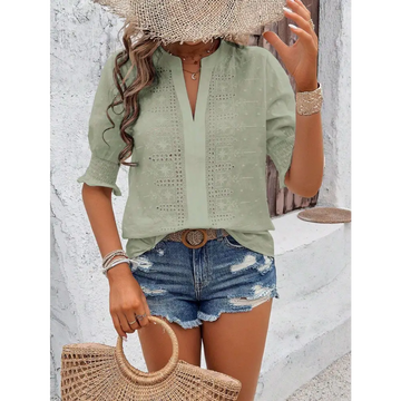 Light green short-sleeved blouse with delicate white eyelet embroidery and v-neckline featuring puff sleeve design