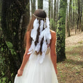 A white featherhead bohemia wedding bridal hair band featuring a delicate white feather and natural-toned band