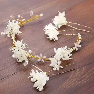 A delicate white floral handmade wreath headwear with gold wire and clear crystal accents for elegant occasions