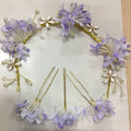A delicate white floral handmade wreath headwear with lavender flowers, gold wire, pearls, and crystal accents