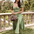 A woman wearing a green floral print dress with puff sleeves and a square neckline in midi length
