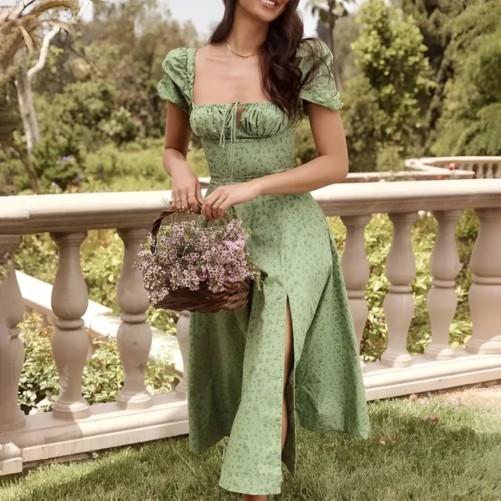 A woman wearing a green floral print dress with puff sleeves and a square neckline in midi length