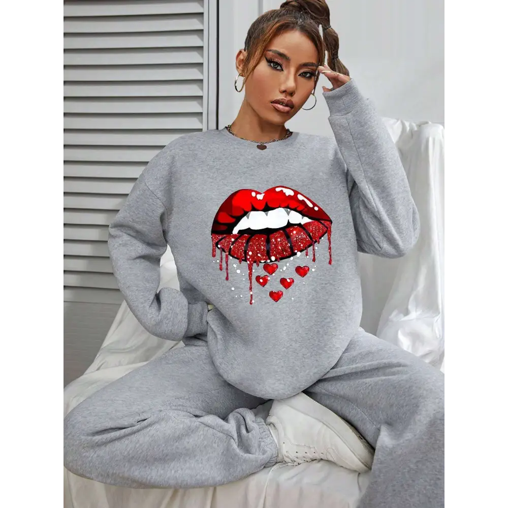 Gray pocketed long sleeve sweatshirt featuring bold red white glitter lips graphic with dripping design and small hearts