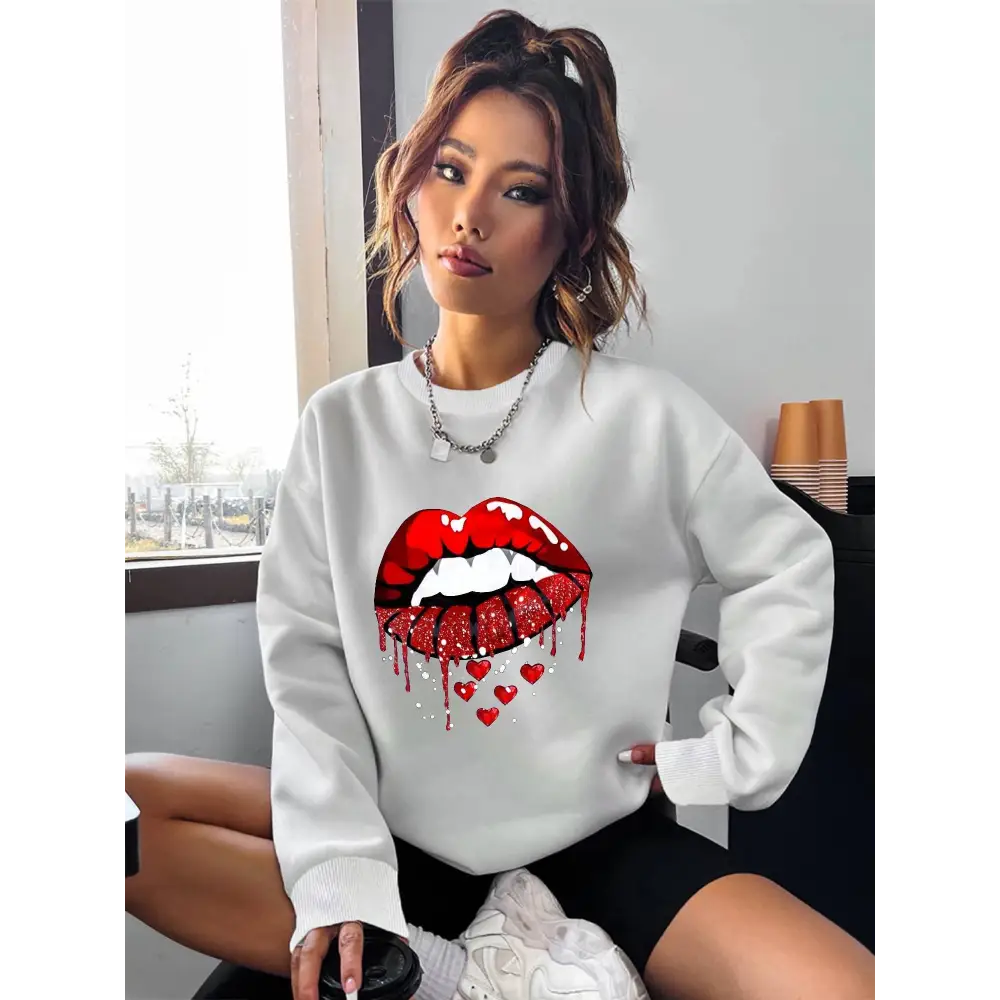 White pocketed long sleeve sweatshirt featuring bold red glitter lips graphic with dripping effect and small hearts below