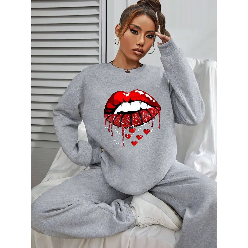 Gray pocketed long sleeve sweatshirt featuring bold red white glitter lips graphic with dripping effect and small hearts below
