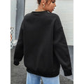 Black oversized long sleeve sweatshirt with ribbed cuffs and hem complementing white graphic leopard hat design