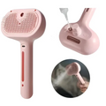 Pink handheld steaming pet hair spray brush with textured bristle head and ergonomic handle for grooming pets