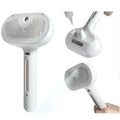 White handheld steaming pet hair spray brush with textured grid-like bristle head and sleek plastic body