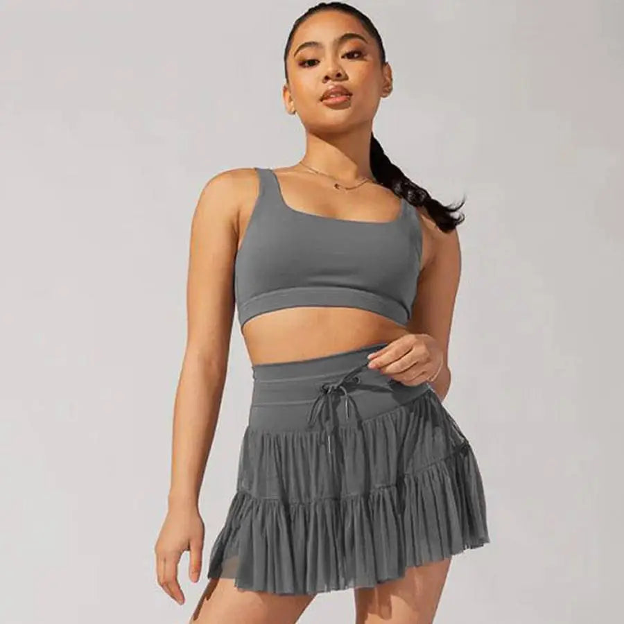 Gray athletic two-piece set with crop top and tiered ruffle skirt featuring waist pleated skirt and safety pants summer design