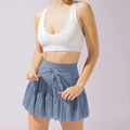 White high waist pleated skirt with safety pants summer features a light blue tiered pleated skirt and bow waistband