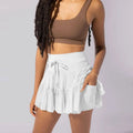 White high waist pleated skirt with tiered ruffles and matching drawstring waistband featuring safety pants summer design