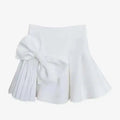 White high waist slimming pleated skirt with a large waist slimming bow and midi skirt length detail