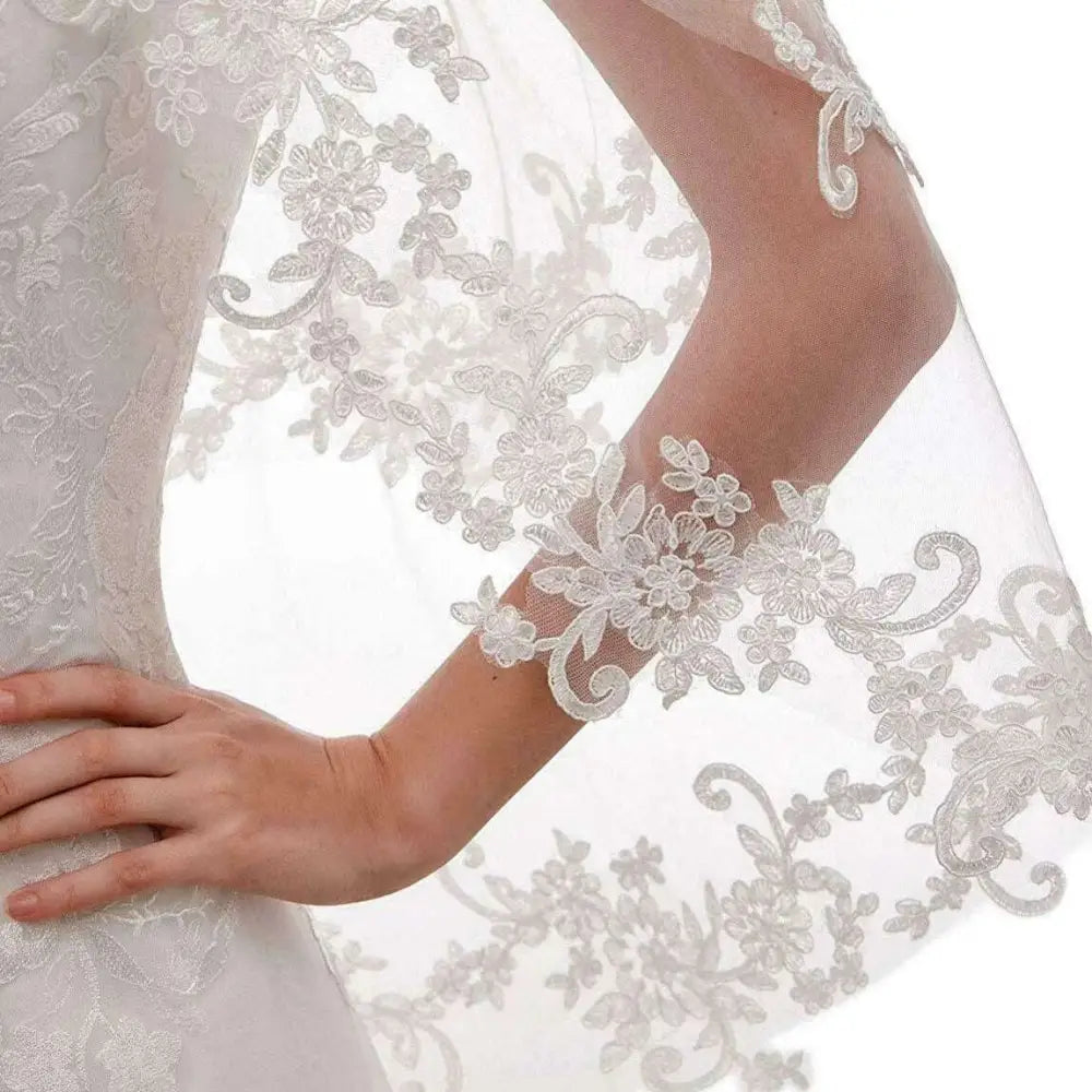 A delicate white ivory applique floral bridal veil with intricate embroidery on sheer mesh base