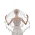 A delicate white ivory bridal veil featuring intricate ivory embroidery applique floral details along the edges