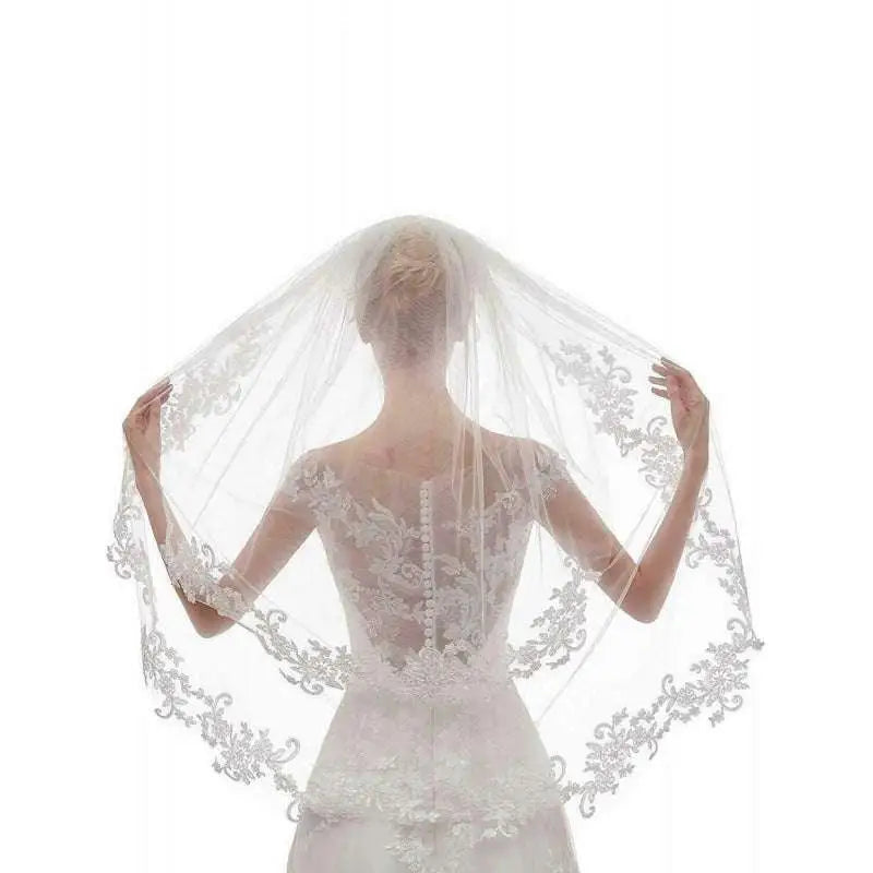 A delicate white ivory bridal veil featuring intricate ivory embroidery applique floral details along the edges