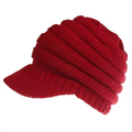 A vibrant red knitted women ponytail beanie with ribbed texture and brim suitable for outdoor wear