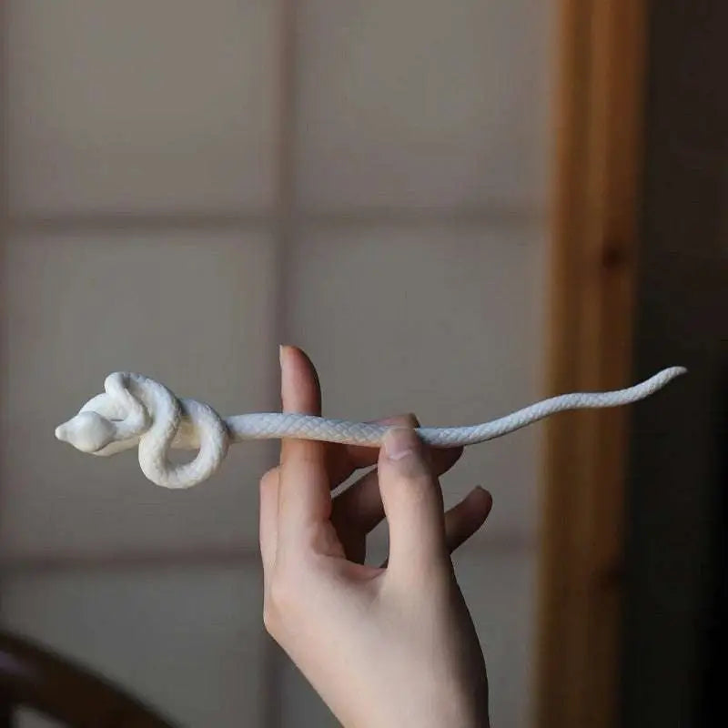 White knotted rope retro style hairpin featuring a delicate white ceramic intricately coiled snake design