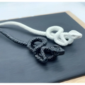 Black and white intricately coiled snake pendant necklaces complement white knotted rope retro style hairpin designs