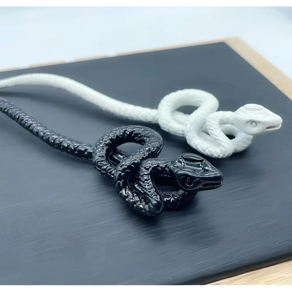 Black and white intricately coiled snake pendant necklaces complement white knotted rope retro style hairpin designs