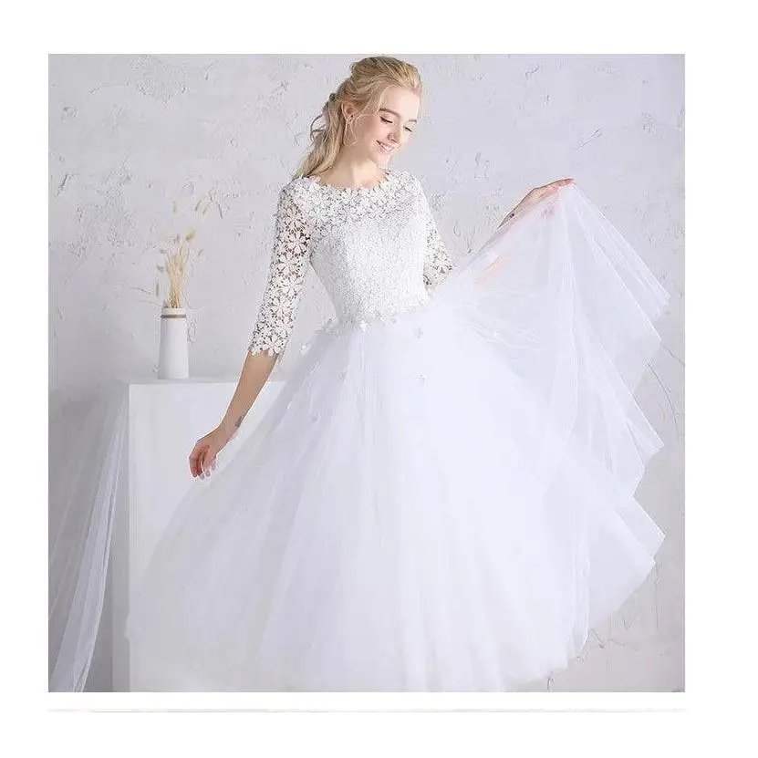 White lace floral wedding dress with small sleeves featuring lace detailing and a voluminous tulle skirt