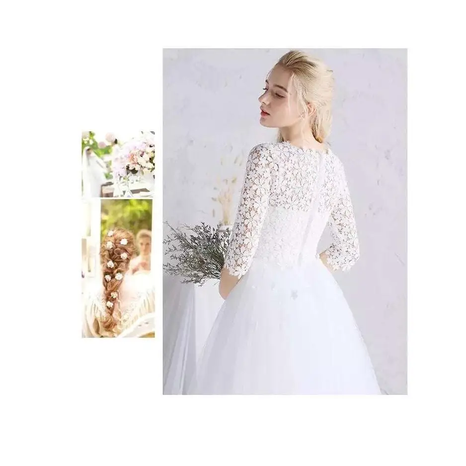 White lace floral wedding dress with small three-quarter length sleeves featuring intricate floral embroidery